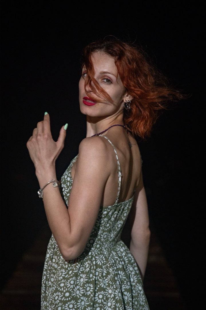 Over-the-shoulder portrait in a floral sundress, hair in motion
